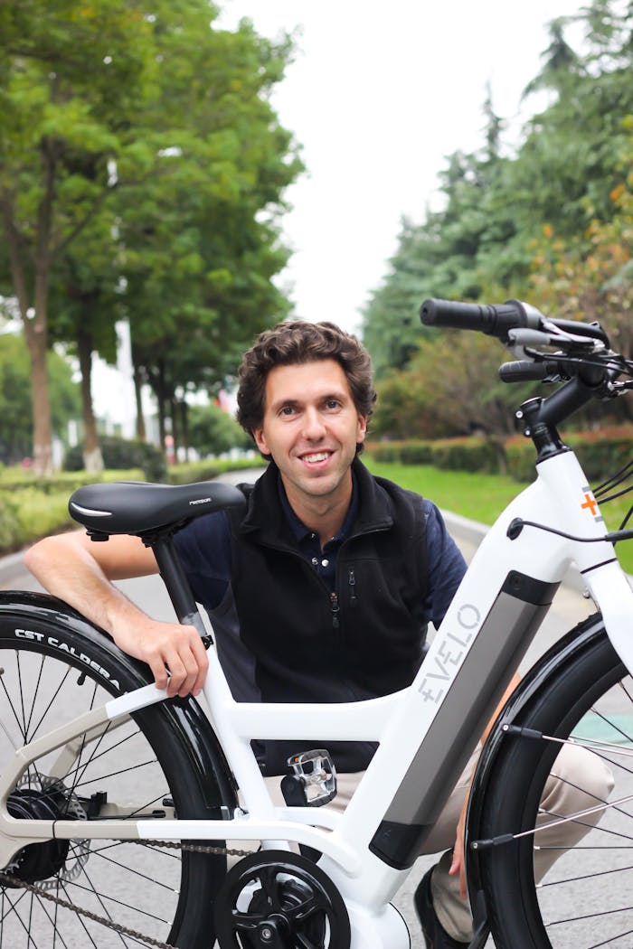 about-us A cheerful man poses with an EVELO electric bicycle on a sunny day.